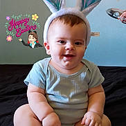 Xavier is registered to the contest to win money with this photo: baby, black_surface, blue_shirt, bunny_ears, child, cross_legged, cute, easter, hand, happy_easter_text, headwear, holiday, indoor, infant, playful, portrait, sitting, smiling, spoon, wall_decoration