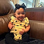 baby, child, smiling, headband, bow, yellow_outfit, black_hearts, sitting, couch, leather, window, curtains, happy, indoors, person, infant, cute, portrait, black_tights, furniture
