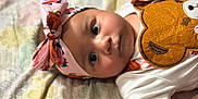 Emelia joined the competition — help win amazing prizes! baby, infant, headband, flower_pattern, teddy_bear, cute, closeup, face, eyes, clothing, white_shirt, lying_down, blanket, patterned, child, adorable, soft_lighting, indoor, portrait, young