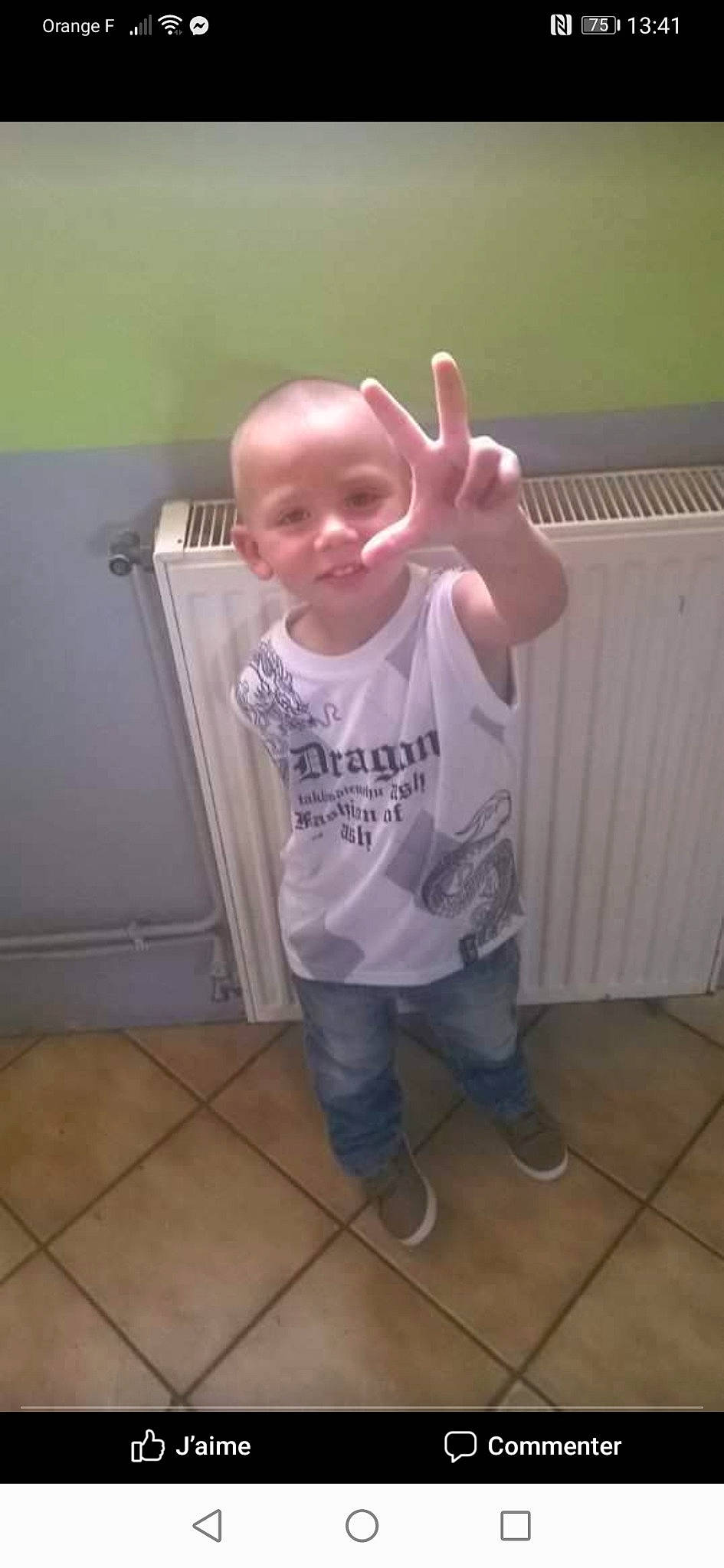 Enzo participe au concours pour gagner de l'argent avec cette photo : baby, baby_toddler_clothing, cheek, child, costume, eyewear, floor, flooring, fun, gesture, happy, hardwood, person, personal_protective_equipment, play, room, sleeve, t_shirt, thumb, toddler