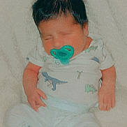 Aurelio Amor joined the competition — help win amazing prizes! baby, newborn, sleeping, pacifier, clothing, dinosaur_print, socks, blanket, infant, cute, soft_texture, indoors, resting, child, portrait, cozy, small_hands, small_feet, cute_outfit, peaceful