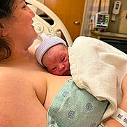 River joined the competition — help win amazing prizes! newborn, baby, mother, hospital, blanket, hat, skin, bed, medical_equipment, hospital_room, person, infant, parent, love, family, healthcare, resting, closeup, intimate, care