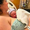 newborn, baby, mother, hospital, blanket, hat, skin, bed, medical_equipment, hospital_room, person, infant, parent, love, family, healthcare, resting, closeup, intimate, care