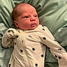 River joined the competition — help win amazing prizes! baby, newborn, infant, onesie, star_pattern, clothing, blanket, soft, bed, sleepwear, person, face, head, skin, cute, small, child, indoors, resting, portrait