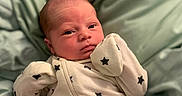 River joined the competition — help win amazing prizes! baby, newborn, infant, onesie, stars, bed, bedding, blanket, sleepwear, child, cute, face, portrait, lying_down, soft, cozy, indoors, skin, head, expression