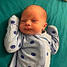 River joined the competition — help win amazing prizes! baby, infant, onesie, blue_clothing, smiley_face_pattern, blanket, bed, lying_down, cute, newborn, pale_skin, head, face, small_hands, sleepwear, child, indoors, portrait, resting, soft_fabric