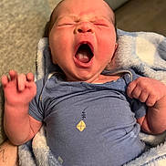 River is registered to the contest to win money with this photo: newborn, baby, yawning, blue_onesie, blanket, infant, cute, sleepy, small_hand, tattooed_arm, soft_texture, indoor, person, portrait, face, expression, clothing, human, wrapped, cozy
