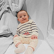 Louna participe au concours pour gagner de l'argent avec cette photo : baby, infant, smiling, striped_sweater, floral_pants, socks, blanket, couch, cozy, indoors, cute, child, portrait, happy, seated, soft_lighting, warm, comfortable, face, clothing