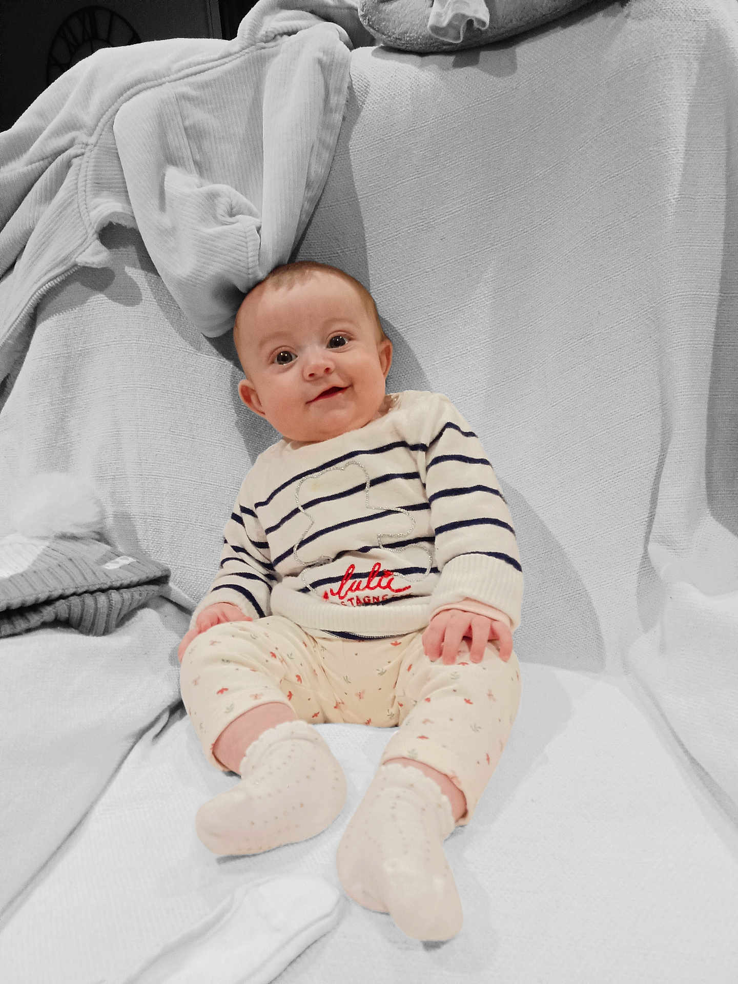 Louna participe au concours pour gagner de l'argent avec cette photo : baby, infant, smiling, striped_sweater, floral_pants, socks, blanket, couch, cozy, indoors, cute, child, portrait, happy, seated, soft_lighting, warm, comfortable, face, clothing