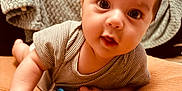 Timéo a rejoint le concours — aidez-le/la à gagner de superbes lots ! baby, infant, face, eyes, cushion, blanket, clothing, striped, lying_down, cute, soft_texture, indoors, child, person, young, skin, hand, expression, curious, cozy