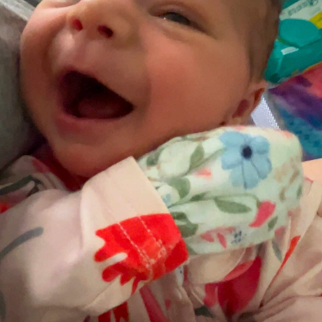 Iris joined the competition — help win amazing prizes! baby, babylaughing, bodypart, clothing, dress, face, fashion, finger, formalwear, gown, hand, happy, hat, head, laughing, newborn, person, photography, portrait, robe