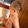 toddler, child, indoor, wooden_wall, toy, curious, wet_hair, side_profile, skin, arm, shoulder, window, daylight, baby, playtime, colorful, candid, young_child, person, light