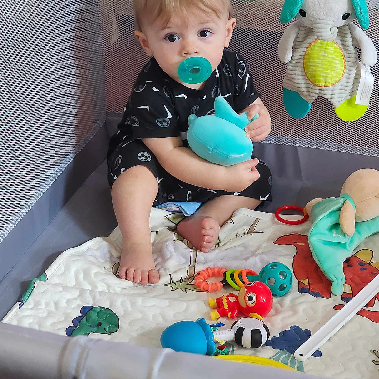 Theodore is registered to the contest to win money with this photo: baby, bed, blanket, bodypart, couch, crib, face, finger, furniture, hand, head, indoors, infantbed, nursery, person, photography, portrait, room, sitting, toy