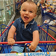 Soan participe au concours pour gagner de l'argent avec cette photo : aisle, baby, black_bag, blue_shirt, child, clothing, face, grocery_store, hand, happy, indoor, luggage, people, person, retail, shopping, shopping_cart, smiling, store, supermarket