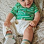 baby, blue_eyes, child, clothing, comfortable, cozy, cute, footwear, fuzzy_blanket, green_shirt, happy, indoor, infant, person, portrait, sitting, smiling, socks, white_pants, white_sneakers