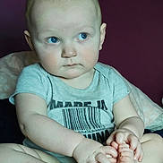 Casanova is registered to the contest to win money with this photo: baby, child, blue_eyes, sitting, onesie, barcode_shirt, barefoot, feet, hands, portrait, indoor, plum_wall, blanket, bed, cute, expression, head, short_hair, ears, skin