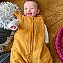 Talia participe au concours pour gagner de l'argent avec cette photo : baby, infant, smile, smiling, sleep_sack, mustard_yellow, sofa, couch, corduroy, pillow, fuzzy_pillow, blanket, cozy, indoor, portrait, happy, cheerful, hand, face, teeth