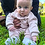 Talia a rejoint le concours — aidez-le/la à gagner de superbes lots ! baby, infant, child, toddler, blue_eyes, pink_clothing, socks, grass, outdoor, park, sitting, portrait, closeup, hand, adult_hands, hair, curious_expression, nature, greenery, daylight