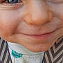 child, face, close_up, smile, blue_eyes, skin, cheeks, nose, mouth, clothing, pattern, fabric, texture, portrait, cute, young, baby, person, innocence, expression