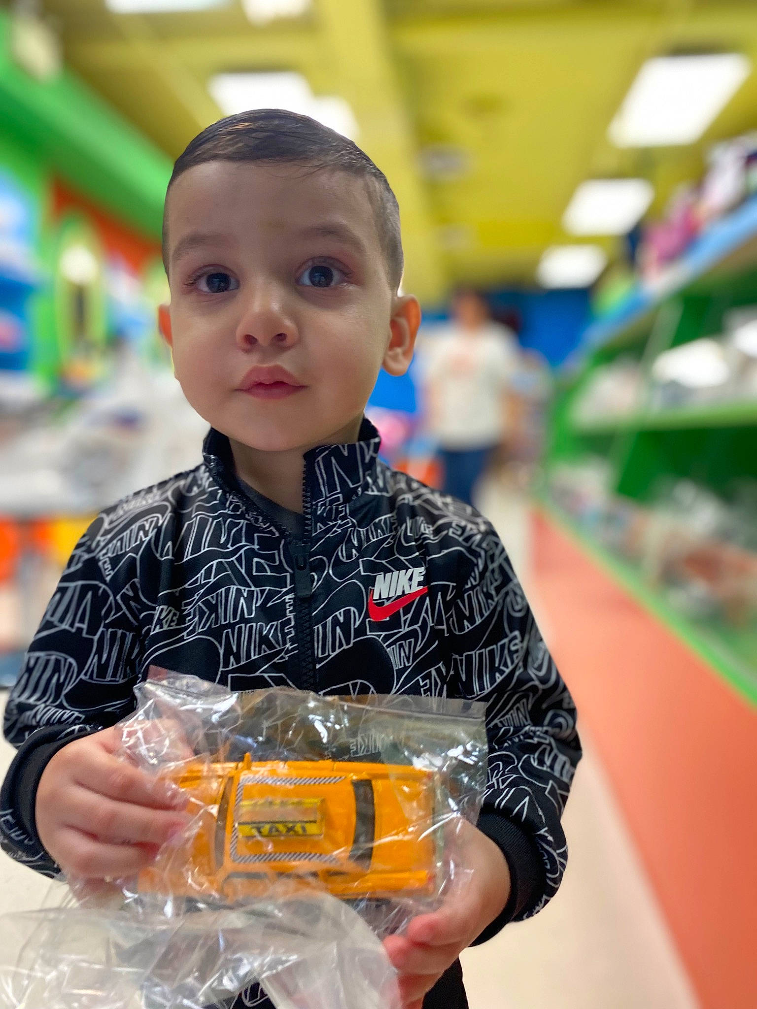 Dennis is registered to the contest to win money with this photo: child, customer, drink, fun, grocery_store, happy, junk_food, person, personal_protective_equipment, plastic, play, retail, shopping, supermarket, t_shirt, toddler, toy, workwear