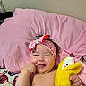 Starlyn joined the competition — help win amazing prizes! baby, infant, child, smiling, happy, portrait, indoors, bed, pillow, pink, headband, plush_toy, duck, toy, lying_down, bare_chested, hand, finger, blanket, bedroom
