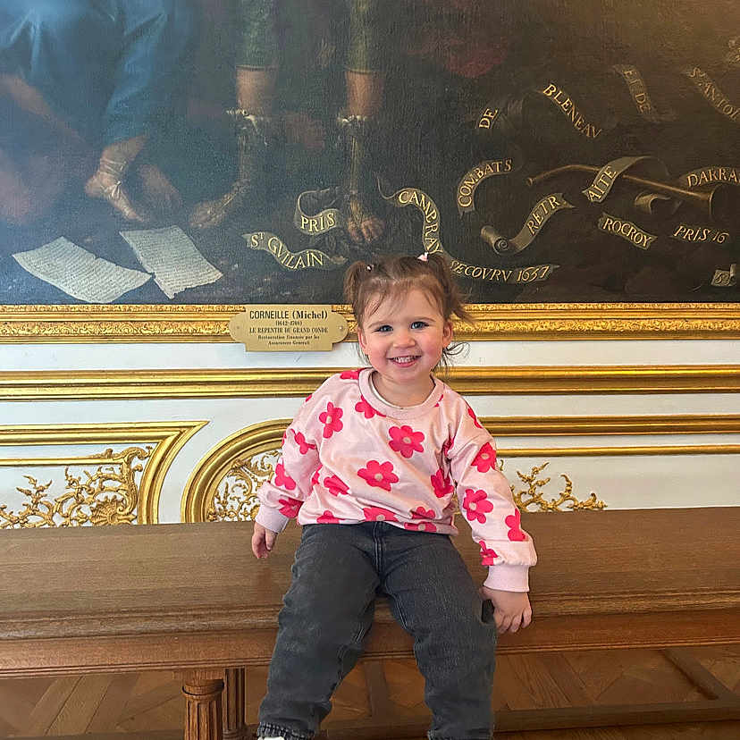Umbelina participe au concours pour gagner de l'argent avec cette photo : bench, child, cute, floral_sweater, gold_trim, hair_bows, happy, indoor, jeans, museum, ornate_frame, painting, pigtails, plaque, portrait_painting, sitting, smile, sneakers, toddler, wooden_bench