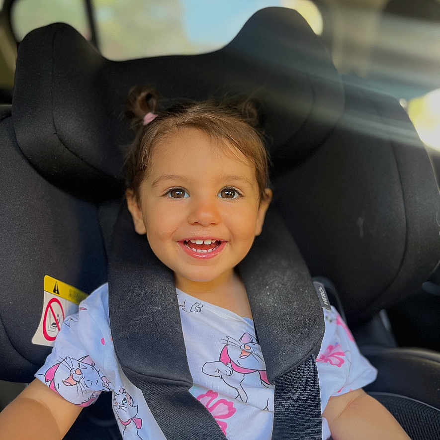 Elia-Maria participe au concours pour gagner de l'argent avec cette photo : baby, car_seat, cartoon_shirt, casual_clothing, child, child_safety, cute, daylight, hair_tied, happy, indoor, portrait, seat, seatbelt, secure, smiling, sunlight, toddler, vehicle_interior, young_child