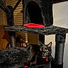 Sparky is registered to the contest to win money with this photo: black_cat, cat_tree, indoor, furniture, pet, animal, yellow_eyes, plush, cozy, curious, relaxed, domestic_cat, feline, red_cushion, window_blinds, wall, collar, bell, scratching_post, resting
