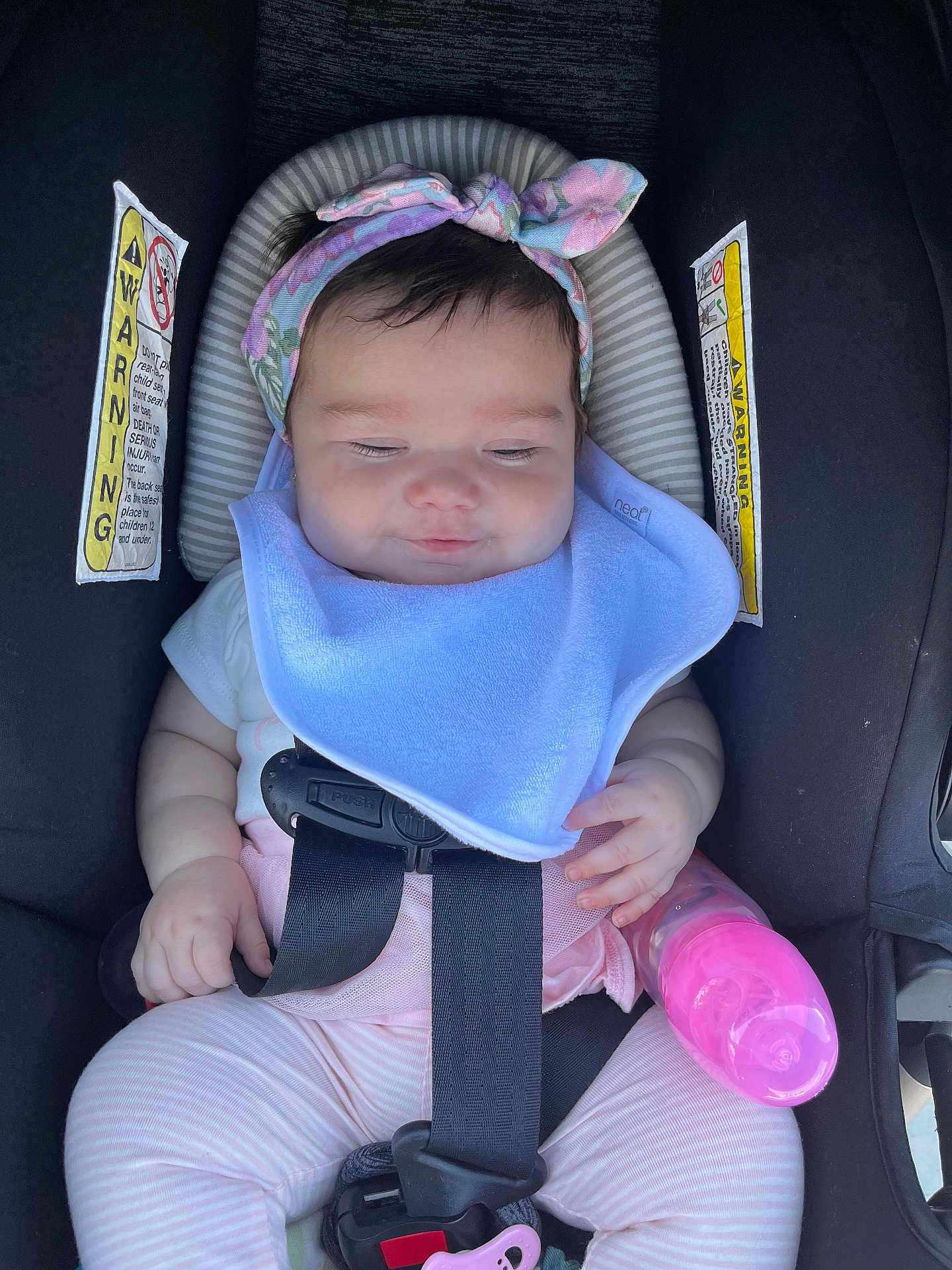 Sofia is registered to the contest to win money with this photo: baby, car_seat, headband, bib, bottle, pink, straps, infant, child, seatbelt, clothing, cute, portrait, sitting, hand, face, expression, indoors, safety, rest