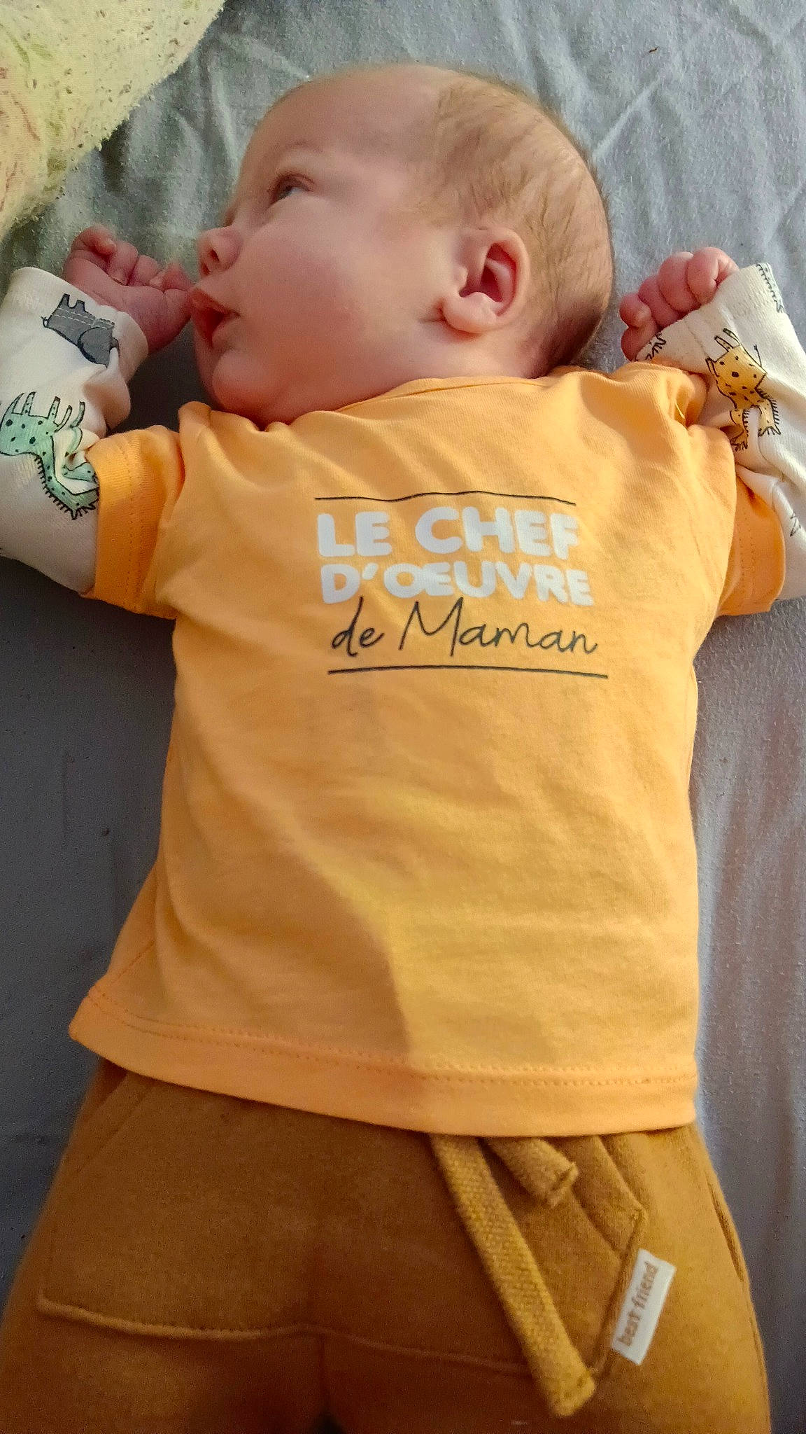 Luc participe au concours pour gagner de l'argent avec cette photo : abdomen, baby, baby_toddler_clothing, cheek, child, eye, eyelash, finger, font, happy, neck, orange, pattern, person, skin, sleeve, sportswear, t_shirt, toddler, trunk