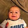 Louis joined the competition — help win amazing prizes! baby, child, infant, smiling, face, portrait, white_shirt, nike_logo, couch, blanket, indoor, lying_down, happy, cute, young_child, head, skin, person, clothing, fabric