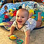 baby, infant, smiling, playing, toys, carpet, playmat, indoors, child, cute, happy, clothing, person, baby_toy, floor, crawling, colorful, young, head, face