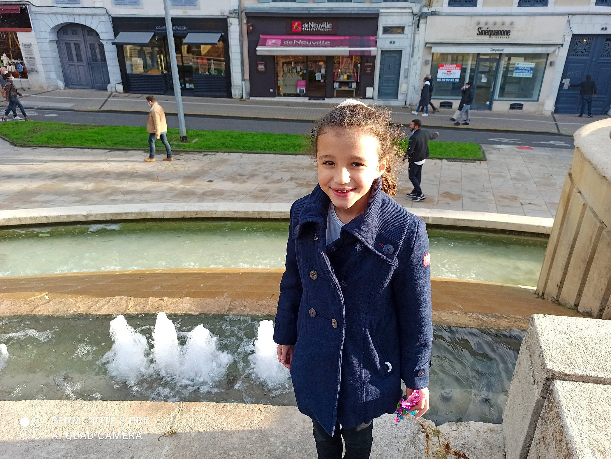 Jenna participe au concours pour gagner de l'argent avec cette photo : city, fountain, fun, human_settlement, joy, leisure, person, plant, recreation, sitting, sleeve, smile, snapshot, standing, street_fashion, temple, toddler, tourism, travel, tree