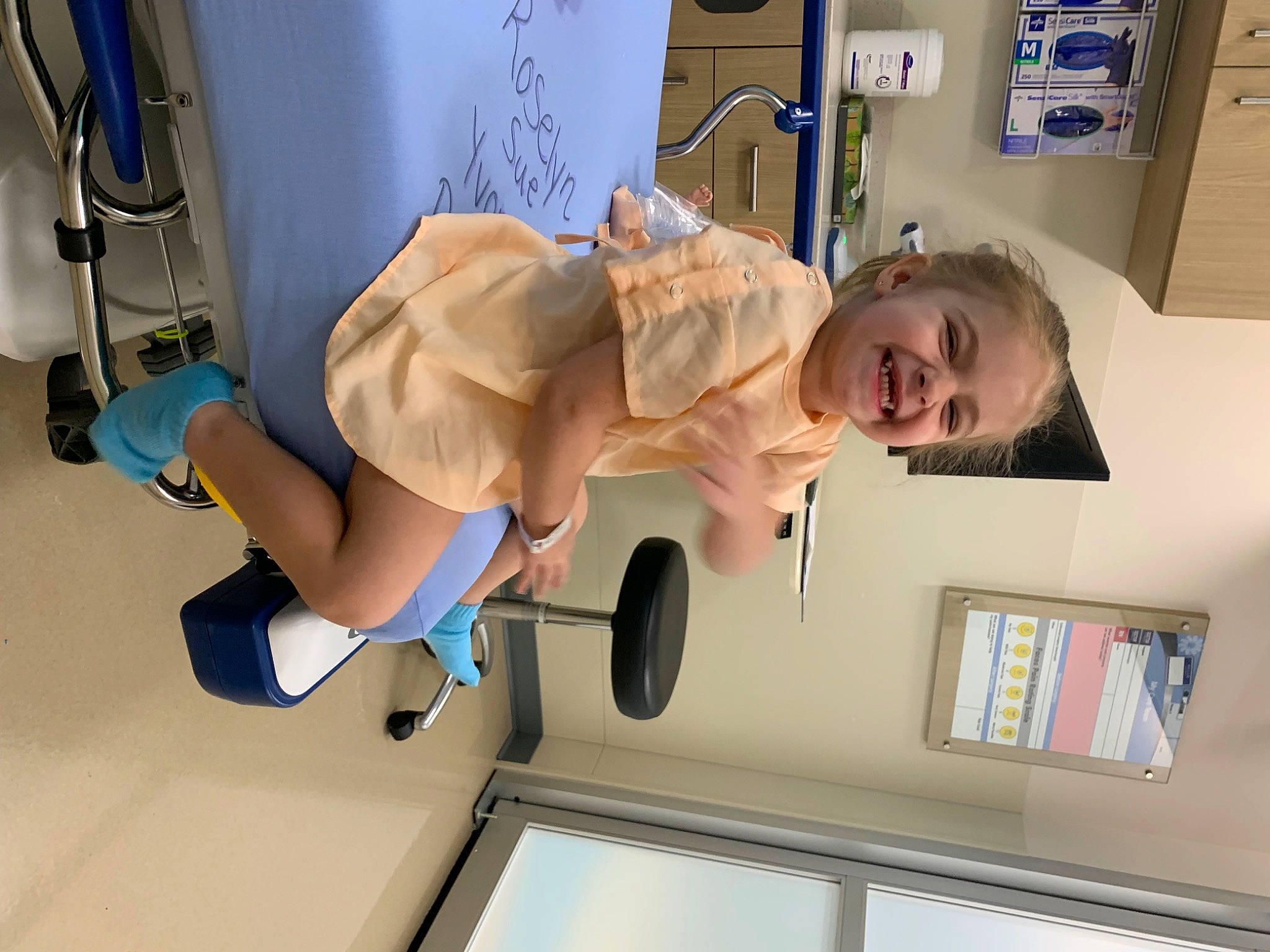 Roselyn is registered to the contest to win money with this photo: baby, clinic, elbow, health_care, hospital, human_leg, joy, knee, medical, medical_equipment, medical_procedure, patient, person, room, service, shorts, smile, t_shirt, thigh, tire