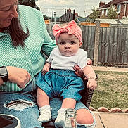Phoebe is registered to the contest to win money with this photo: baby, child, adult, woman, outdoor, garden, grass, fence, clothing, headband, denim, shoes, bottle, person, jeans, ripped_jeans, sitting, portrait, sky, casual