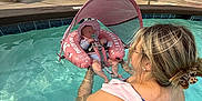 Sinclair joined the competition — help win amazing prizes! baby, baby_float, babywearing, child, floating, holding, inflatable_float, leisure, outdoor, person, pool, poolside, relaxation, residential_building, summer, sunshade, swimsuit, water, water_activity, woman