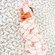 Sinclair is registered to the contest to win money with this photo: baby, bed, blanket, bow, child, cute, expression, fabric, face, headband, infant, lying_down, newborn, pattern, person, pink, sheet, soft, swaddled, wrapped