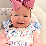 Sinclair joined the competition — help win amazing prizes! baby, child, smiling, pink_bow, floral_dress, daddys_girl, cushioned_chair, infant, cute, happy, portrait, indoors, headband, person, baby_clothes, baby_girl, close_up, cheerful, seated, plush