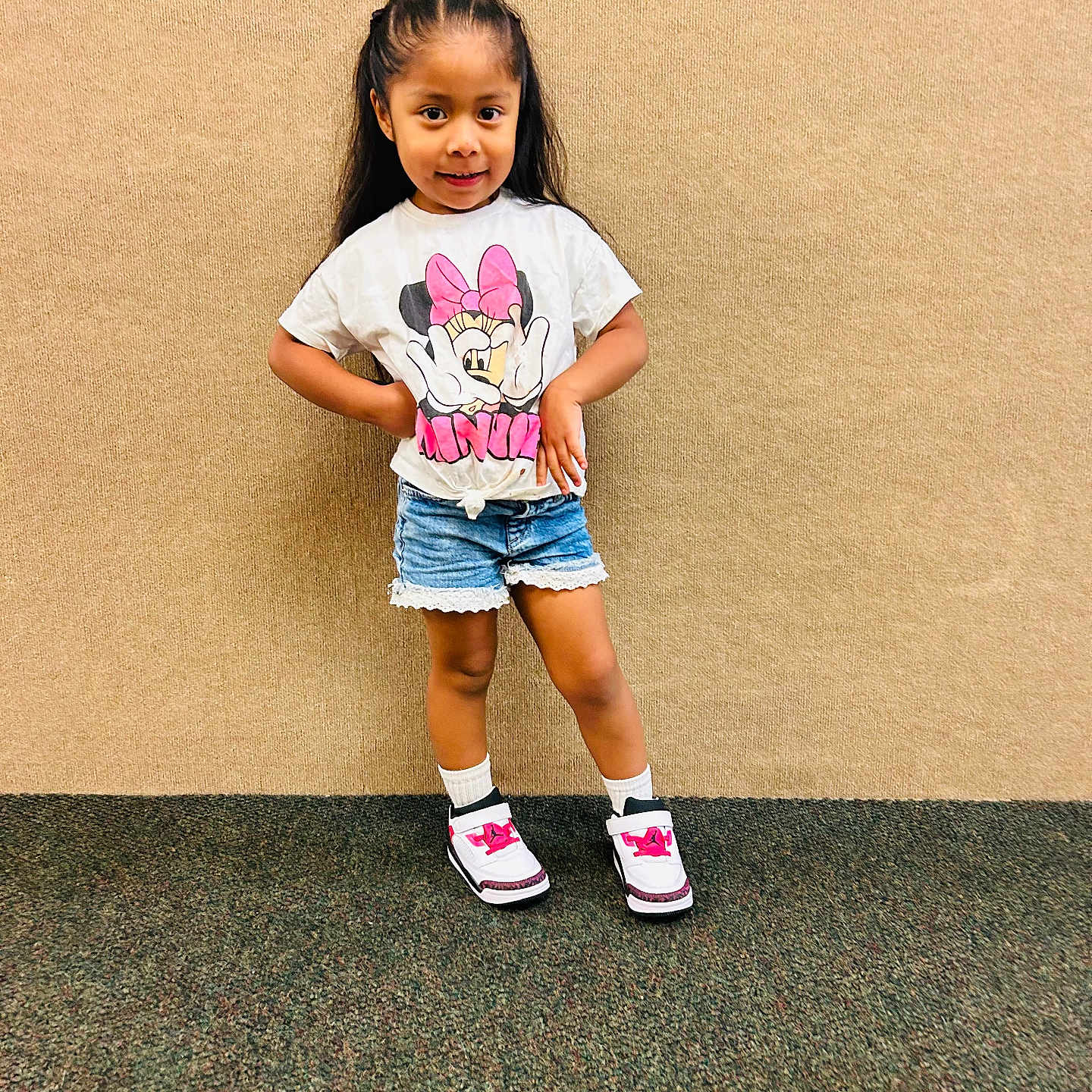 Eulalia is registered to the contest to win money with this photo: child, girl, portrait, standing, smiling, posing, indoors, fashion, clothing, t_shirt, shorts, sneakers, socks, minnie_mouse, cartoon, long_hair, braids, carpet, wall, full_body