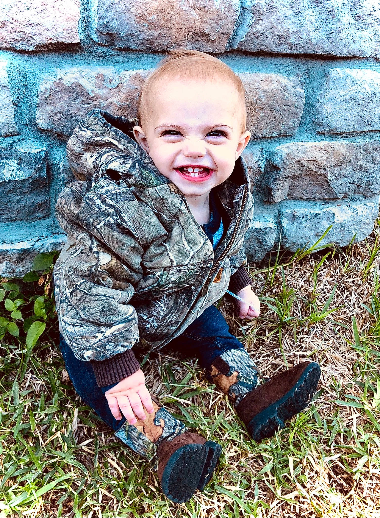 Conway is registered to the contest to win money with this photo: baby, blue, child, fun, garden, grass, hand, happy, joy, landscape, lawn, leisure, people_in_nature, person, plant, shoe, sitting, smile, sneakers, soil
