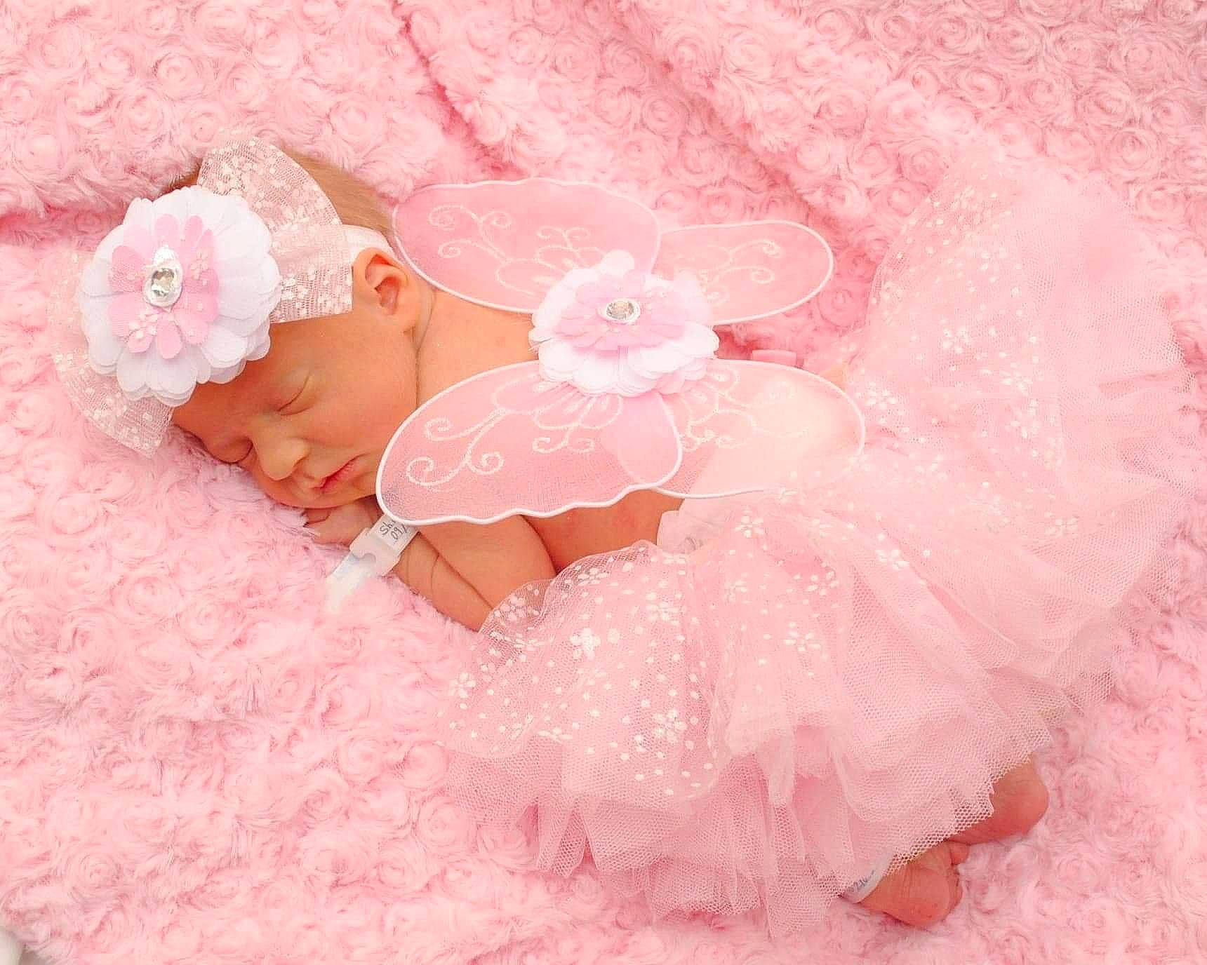 Novalynn is registered to the contest to win money with this photo: baby, child, costume, hair_accessory, headgear, headwear, peach, person, petal, pink, product, toddler