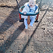 Reginald is registered to the contest to win money with this photo: baby, swing, playground, child, sunlight, shadow, happy, outdoor, clothing, woodchips, seat, smile, person, toy, fun, daylight, park, babywear, activity, recreation