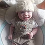 baby, smiling, hat, knitted, bear_ears, overalls, beige_clothing, white_shirt, baby_seat, cushion, happy, infant, cute, child, small_hands, indoor, portrait, person, clothing, headwear