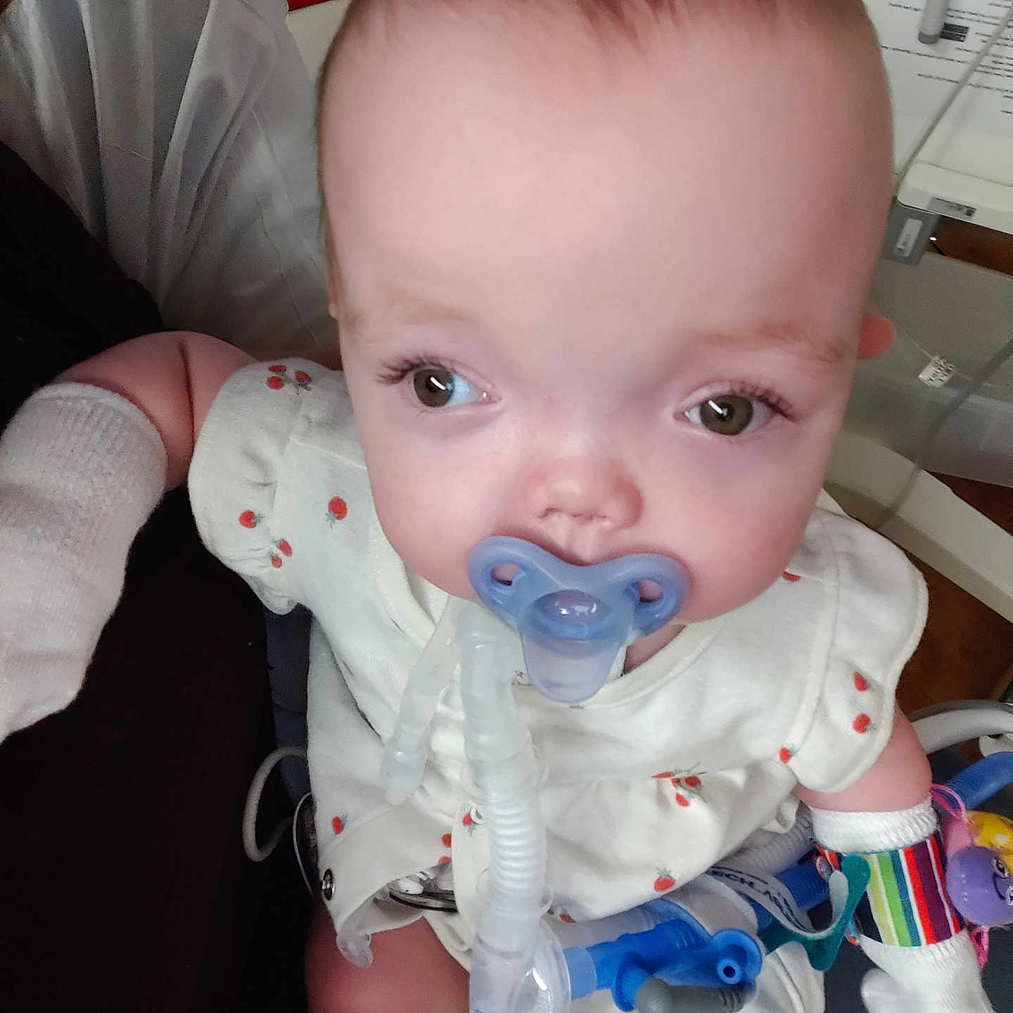 Aline joined the competition — help win amazing prizes! baby, baby_clothes, child, close_up, cute, facial_expression, healthcare, hospital, indoors, infant, medical_care, medical_equipment, medical_tubes, mittens, pacifier, patient, person, sitting, white_outfit, young_child