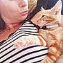 affection, casual, cat, closeup, collar, couch, cute, face, fur, indoor, light, necklace, orange_tabby, paw, pet, portrait, relaxing, striped_shirt, sunbeam, woman