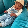 baby, child, smile, hat, cap, overalls, blue, white, cushion, chair, indoor, happy, person, infant, clothing, relaxing, cute, portrait, sitting, cozy