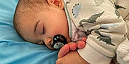 Lysandre participe au concours pour gagner de l'argent avec cette photo : baby, blue_blanket, child, closeup, comfort, cozy, cute, dinosaur_pattern, ear, face, fingers, hand, infant, pacifier, pajamas, peaceful, rest, skin, sleeping, soft