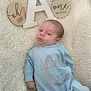 Anthony joined the competition — help win amazing prizes! baby, infant, one_month, blue_clothing, blanket, wooden_sign, face, person, portrait, laying_down, cute, newborn, soft_texture, expression, child, home, cozy, milestone, sleepwear, small