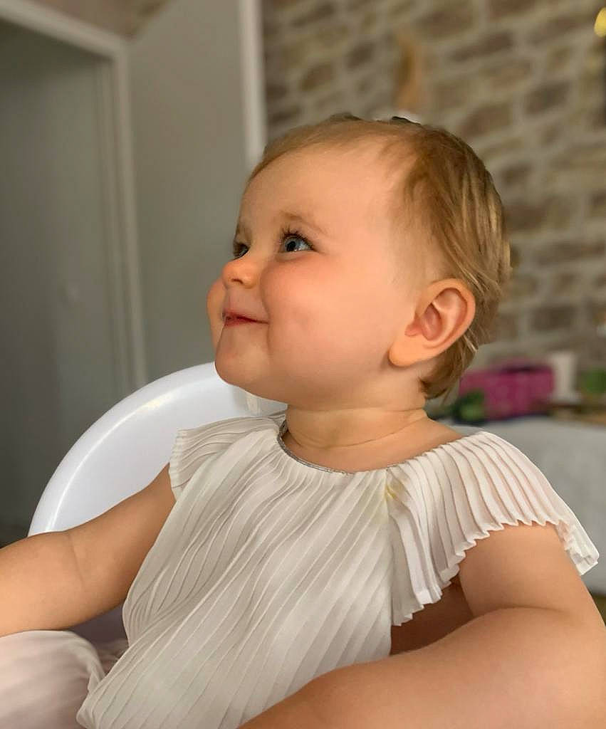 Cali a rejoint le concours — aidez-le/la à gagner de superbes lots ! baby, baby_toddler_clothing, blond, cheek, child, comfort, eye, hairstyle, happy, human_leg, iris, joy, lip, neck, person, portrait_photography, sitting, skin, sleeve, smile