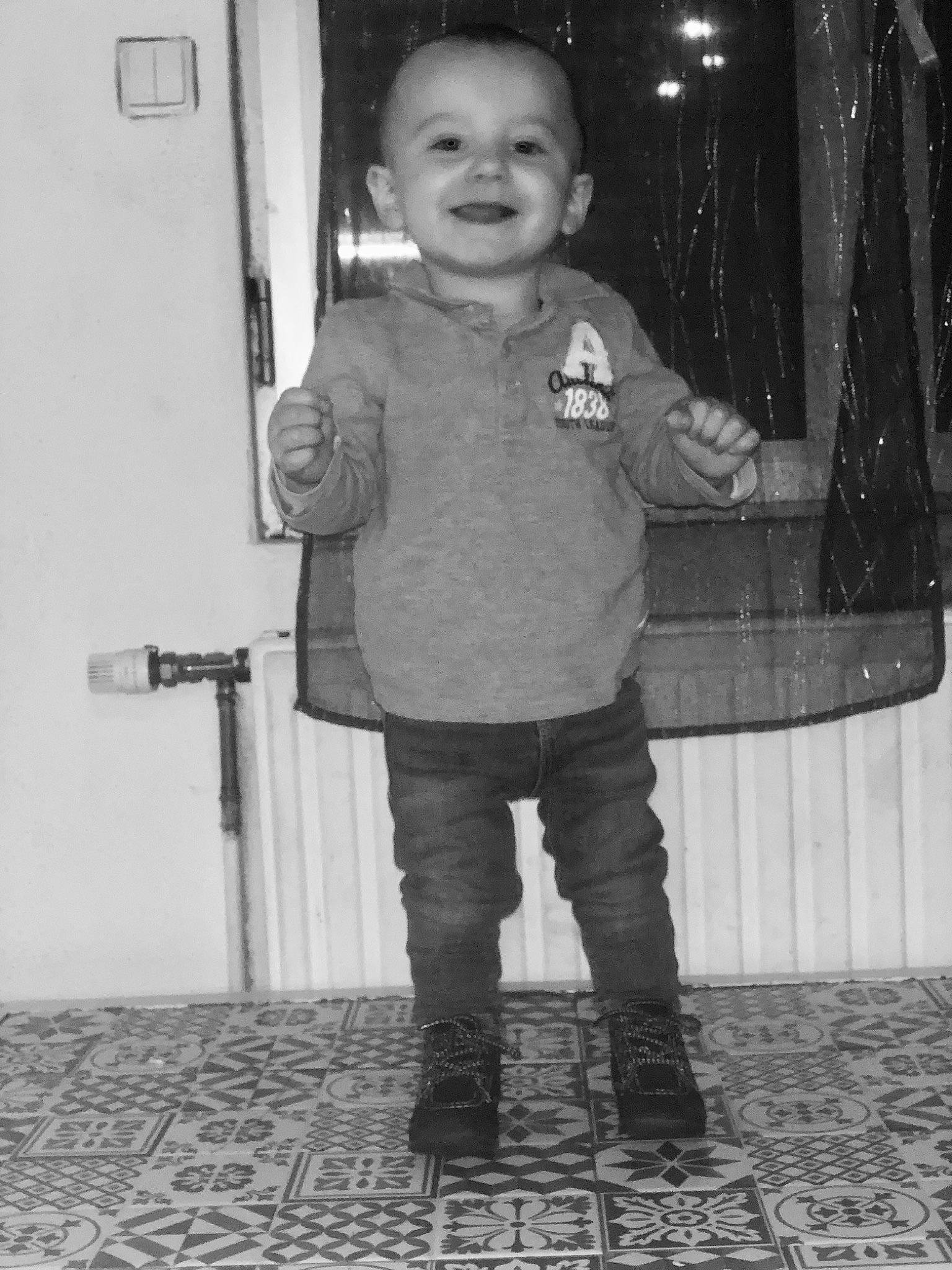 Rayann participe au concours pour gagner de l'argent avec cette photo : baby, black, black_and_white, child, cobblestone, flooring, fun, gesture, happy, joy, monochrome, monochrome_photography, person, photograph, sleeve, smile, standing, stock_photography, style, toddler